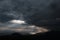 Ominous clouds and the bursting rays of light over the gulf sea