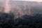 Ominous mystical fog over the forest, halloween background. Evaporation of moisture over the tops of trees after rain, timelapse