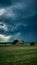 Ominous storm brews over rural farm in dramatic sky