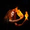 An ominous witch sets her spell book on fire with the power of thought. Red-haired woman conjures for Halloween. Flames