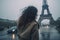 Once in Paris. Back of woman in rain weather against Eiffel tower. Generative AI