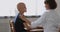 Oncologist doctor during conversation touch shoulder of bald cancer patient