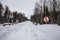 Oncoming traffic sign on a narrow winter road with a bridge in the forest