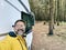 One adult man taking selfie picture outside a camper van motorhome parking in the nature park outdoors with trees. People and
