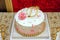 One age D letter gold color. Cake with Number 1 Candle . White cake. Pink flowers