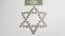 One american dollar banknote lay over Israeli shekel metal coins arranged in a shape of jewish six points star