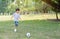 One asian boy enjoying play football toy in park.Boy wearing a striped white blue shirt