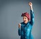 One big cheer for feminism. Studio shot of an attractive young woman standing with her arm raised in celebration against