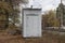 One big gray metal transformer box stands in the dry grass