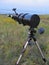 One black complex telescope stands in the meadow at dusk