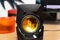 One black computer speaker. With yellow circle details.