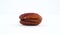 One blanched pecan nut. Rotating on the turntable isolated on the white background. Closeup. Macro.