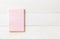 One blank pastel sweet pink color reminder paper pad with horizontal line stripes on white pine wood