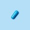 One blue capsule. Pills for men`s health and sexual energy on an isolated background. Concept of erection, potency