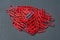 One blue on heap of many red paper clips for office work or education
