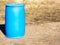 One blue plastic barrels stand on ground