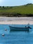 One boat is anchored near the picturesque shores of southern Ireland. Seaside landscape. Green hilly coast, boat on seashore