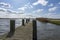 One of the boat docks with mooring posts in the lake de Rottemeren with the windmill Tweemanspolder nr 4 in the background on a su