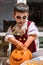 One boy in halloween costume and makeup emptying pumpkin with pen for decorating holiday of Halloween at home. Autumn, fall,