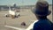 One boy looks at airplane runway in a airport waiting for a trip, close up.