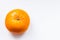 One bright ripe orange glossy tangerine in orange peel on white background