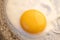 One bright round raw yolk in finish white with edge cracks in a dark skillet. Cooked small fried eggs is a simple breakfast.