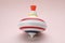 One bright spinning top on beige background. Toy whirligig