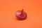 One bright spinning top on orange background. Toy whirligig