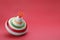 One bright spinning top on red background, space for text. Toy whirligig