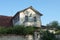 One brown iron balcony in the white attic of a private house with a brown roof