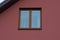 One brown large window on the plastered red wall of a private house