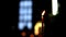 One burning candle in dark room of the Orthodox Church, camera panning up