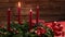 One burning red candle on a traditional advent wreath with festive decoration