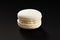 One cake of macaroni white color. Delicious coconut macaroon isolated on black background. French sweet cookie