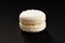 One cake of macaroni white color. Delicious coconut macaroon isolated on black background. French sweet cookie