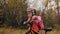 One caucasian children walk with bike in autumn park. Little girl walking black orange cycle in forest. Kid goes do