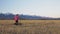 One caucasian children walk with bike in wheat field. Girl walking black orange cycle on background of beautiful snowy