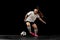 One caucasian energetic woman, soccer, football player in motion isolated on dark background. Sport, action