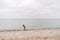 One caucasian man young caucasian woman tourist with a black backpack on a sandy beach near the Baltic sea in winter