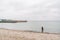 One caucasian man young caucasian woman tourist with a black backpack on a sandy beach near the Baltic sea in winter. Theme trip