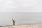 One caucasian man young caucasian woman tourist with a black backpack on a sandy beach near the Baltic sea in winter. Theme trip