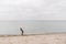 One caucasian man young caucasian woman tourist with a black backpack on a sandy beach near the Baltic sea in winter. Theme trip