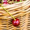 One cherry hanging on wicker basket