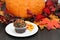 One chocolate cupcake decorated for fall with an autumn backgrou