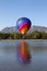 One colorful hot air balloon dipping into a lake