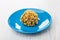 One cookie with peanuts in form ball in blue saucer