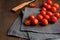 One cutting tomato and tomatoes group on tissue over brown wooden table