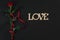 One dark red rose with red ribbon on black background. Romantic Valentines holidays concept. Valentine`s day greeting