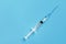 One disposable syringe on a blue background. Space for text