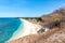 One dollar beach. Idillic yellow sandy beach of East Timor, Timor-Leste. Coastline with hills, mountains and dry savanna.